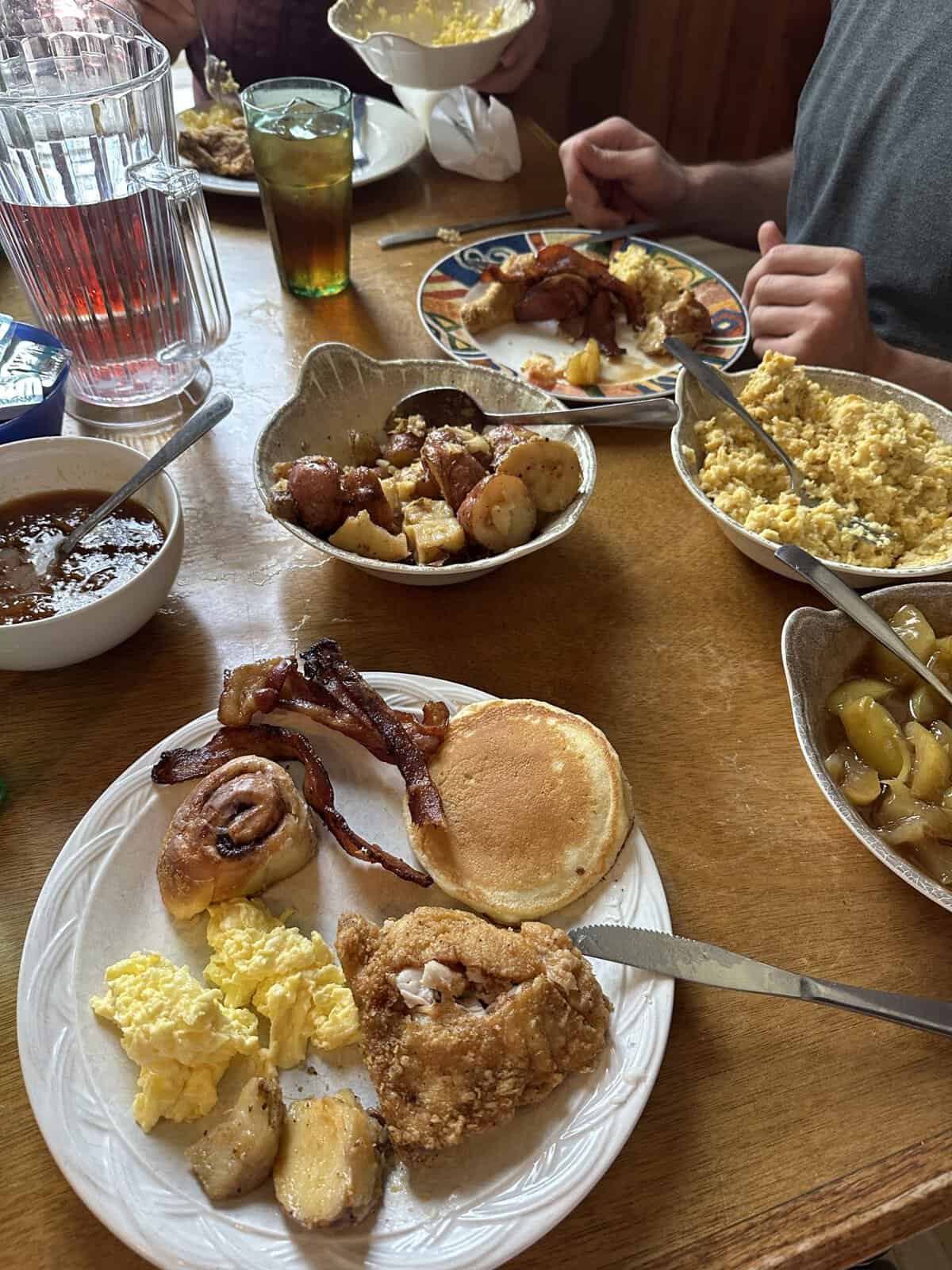 monells_germantown_brunch - Adventures with Carli plate of assorted breakfast foods surrounded by bowls of potatoes, eggs, apples, and beans at monell's in nashville
