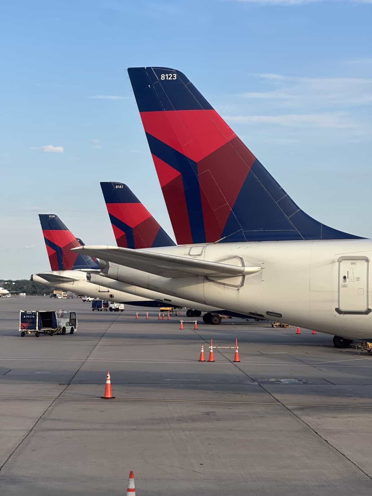 tails of 3 delta planes in a row on tarmac