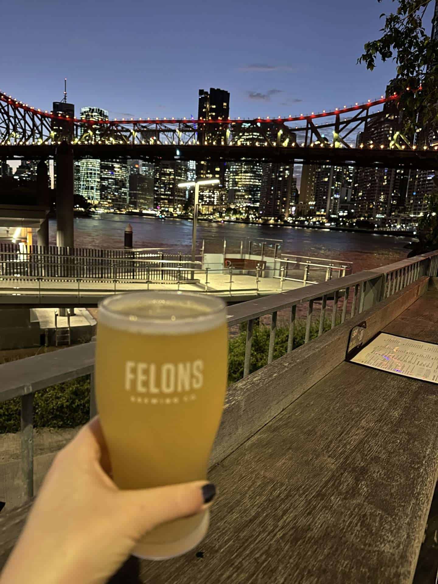 view of a beer and the story bridge from Felons Brewery in Brisbane