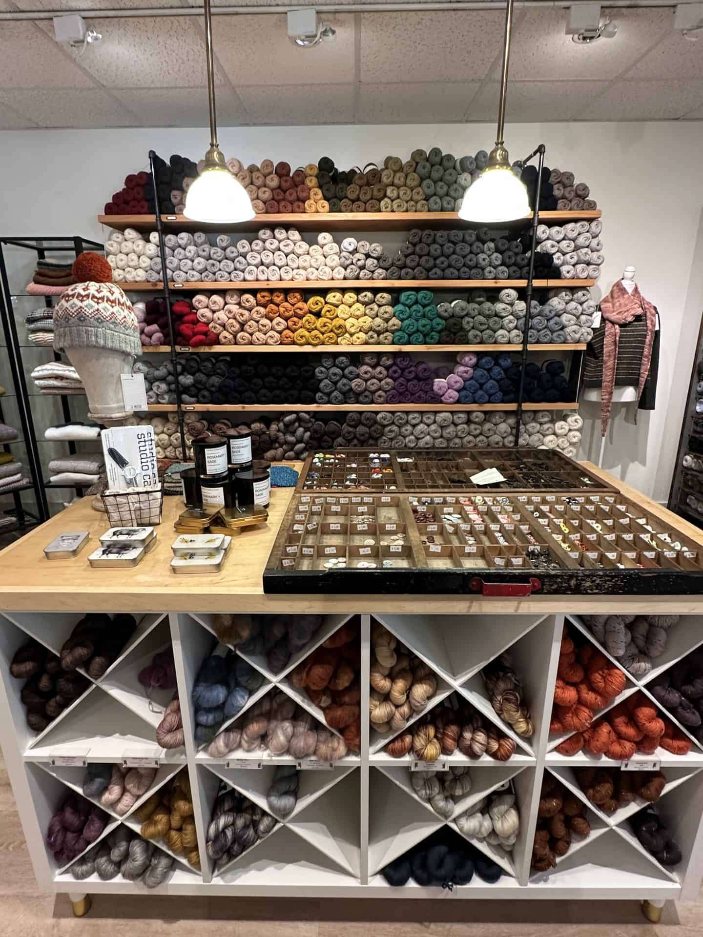 view of yarn store with color coded yarn along back wall