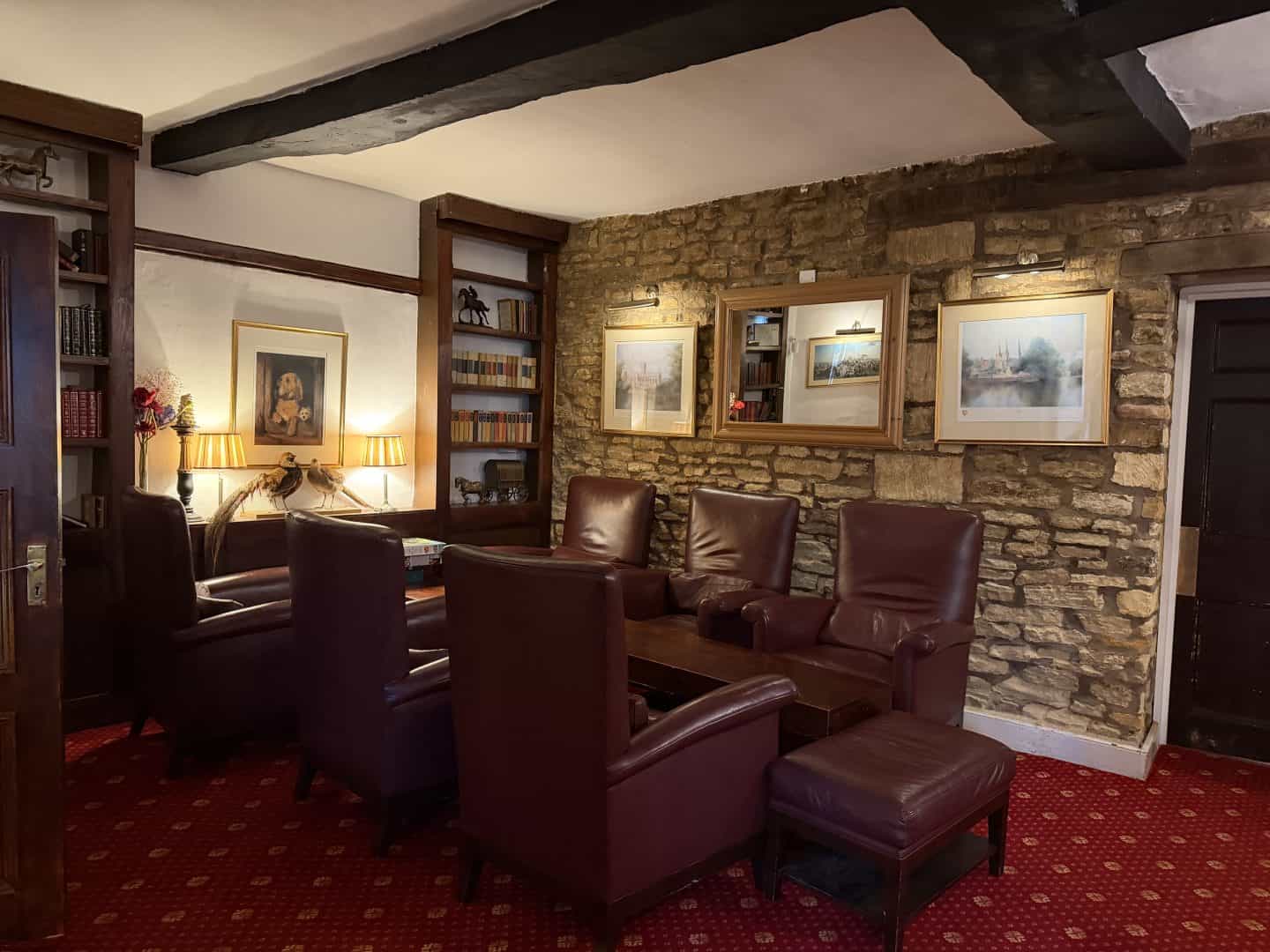seating area with leather chairs and bookshelves in crown hotel blockley