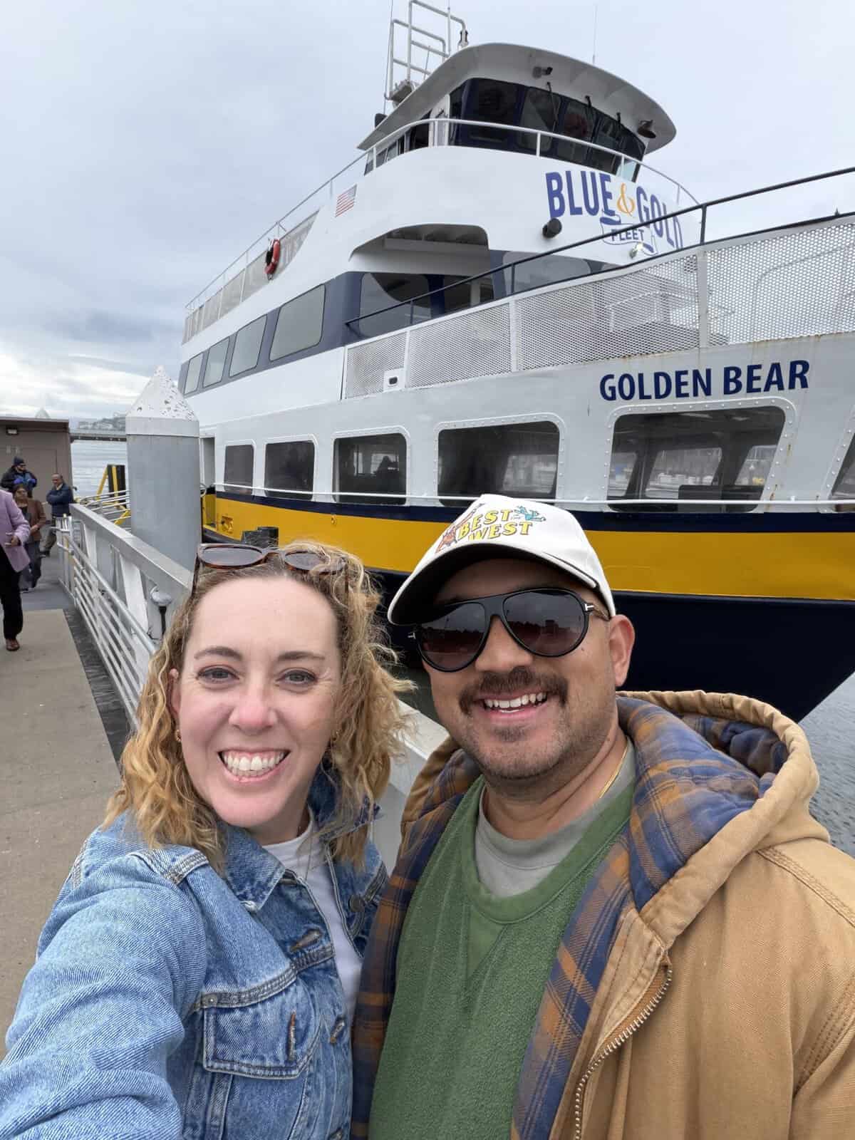 Photo of Carli and male friend AJ in front of blue & gold fleet boat