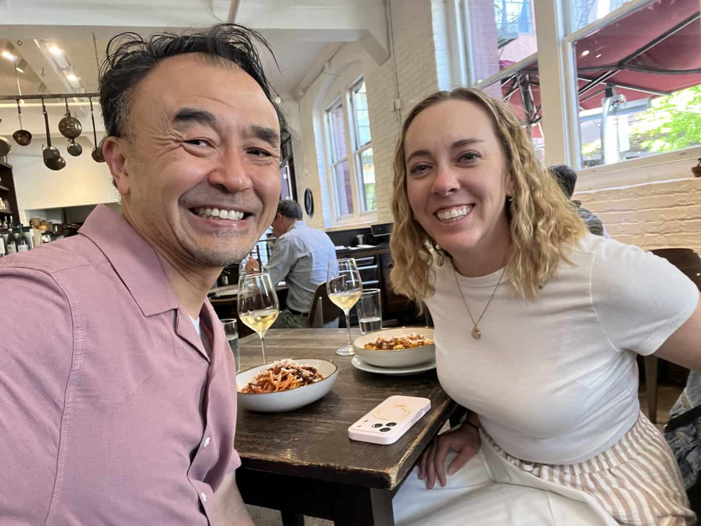 carli and male friend clarence smiling and having italian food for lunch