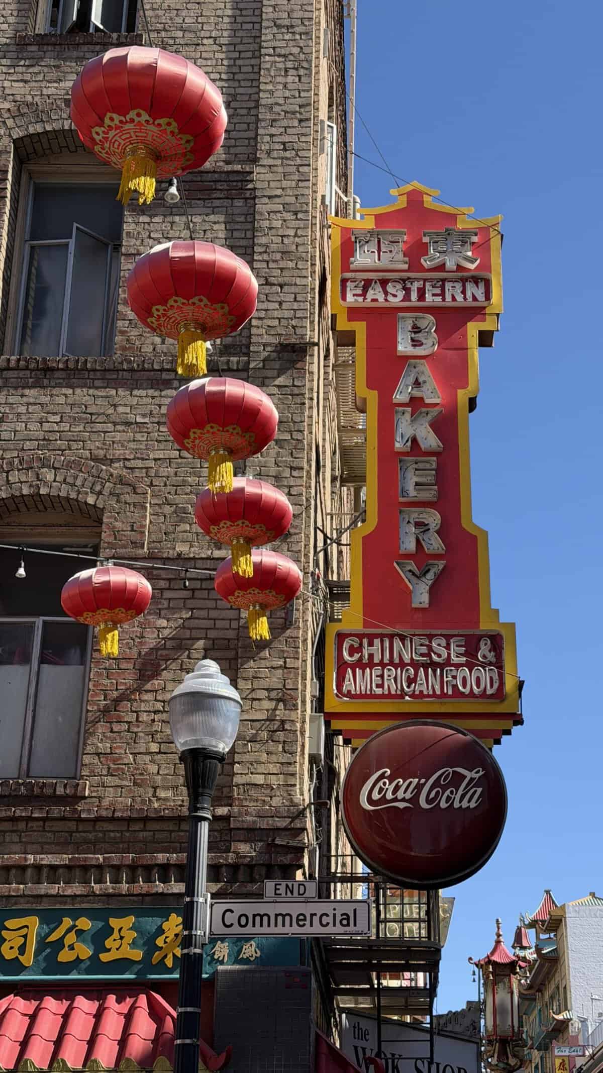 large red sign reading eastern bakery along side of building with red Chinese lanterns hanging nearby
