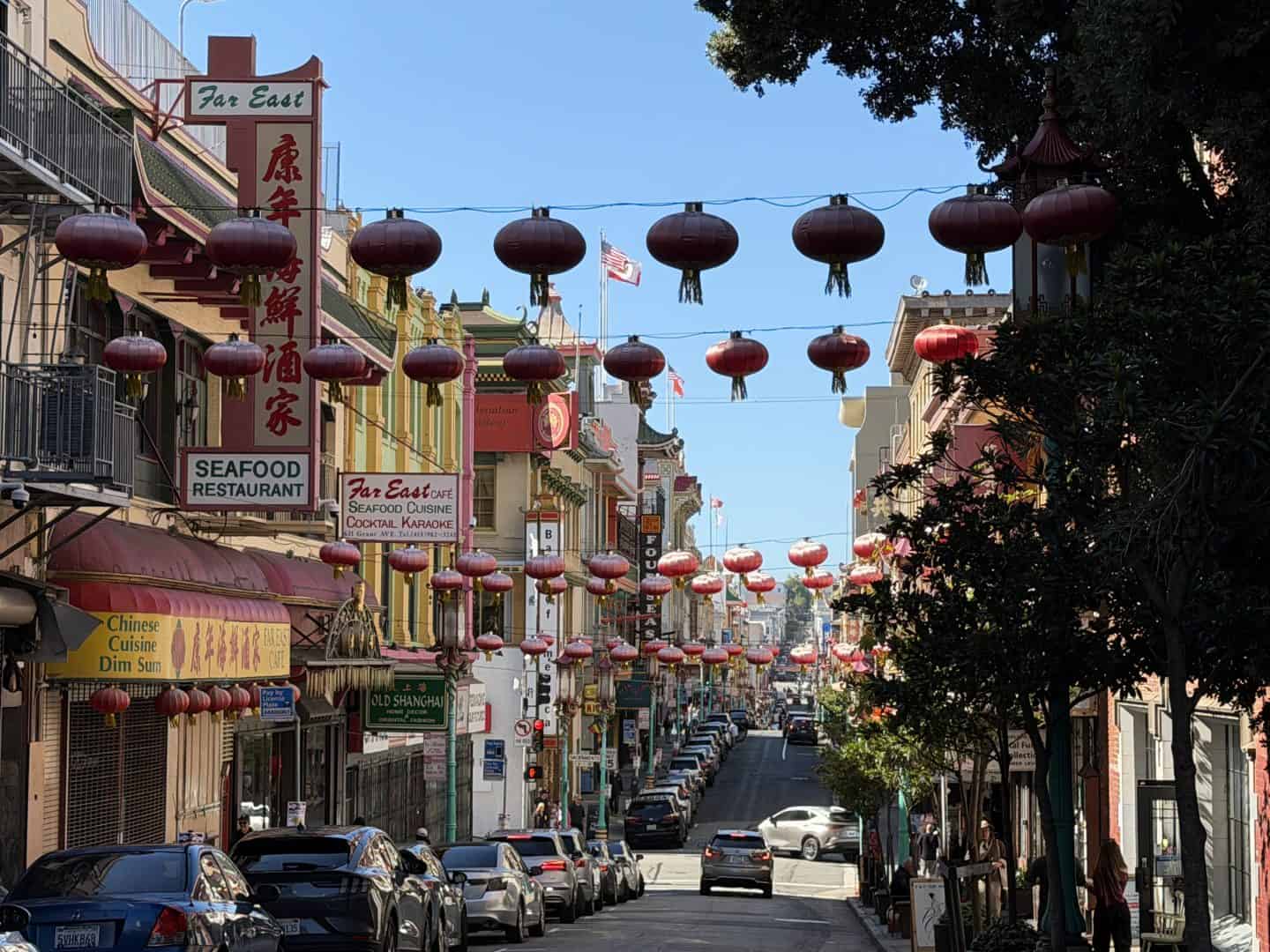 view looking down street in china town with red lanterns strewn across the street