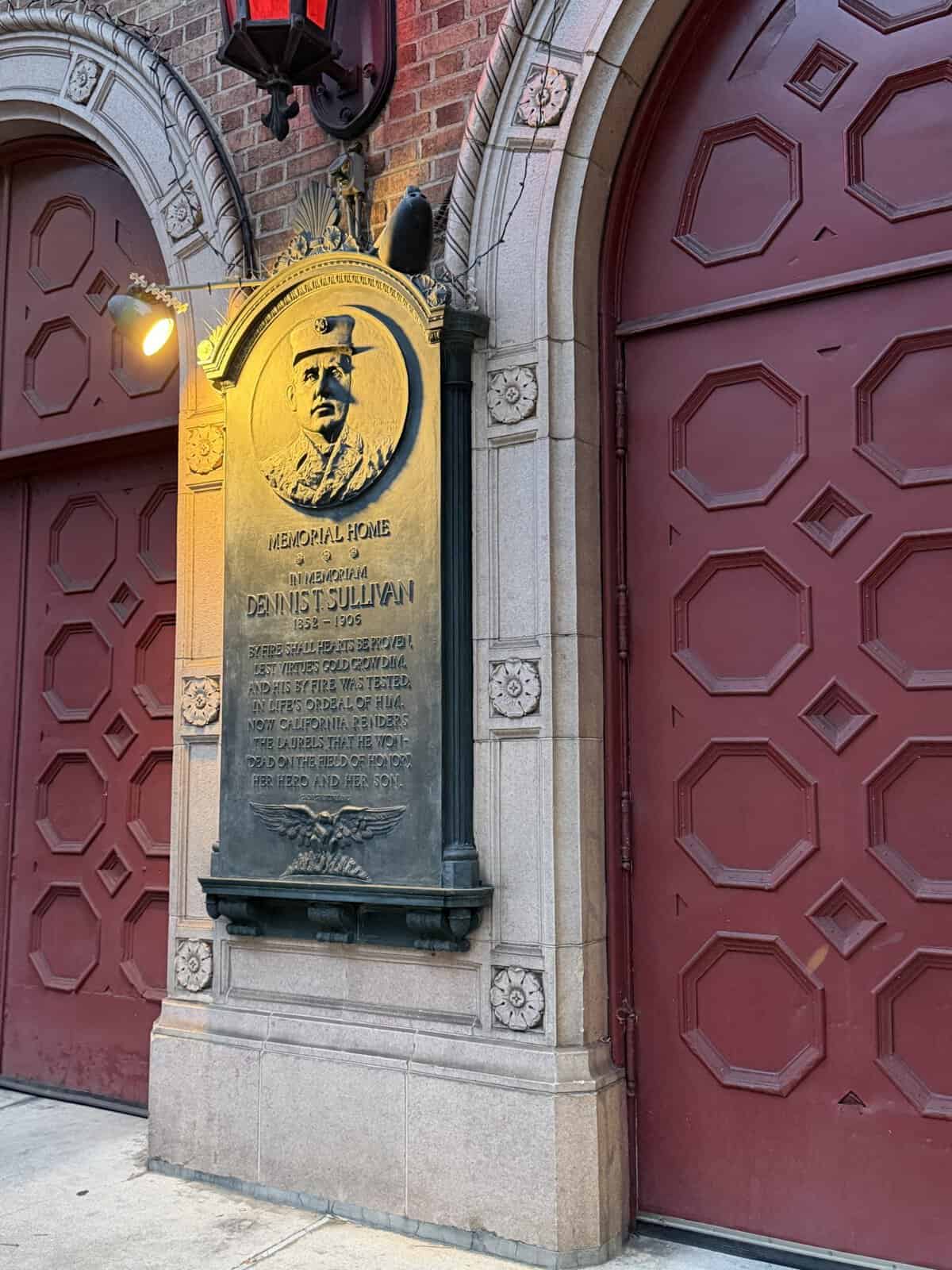 memorial to San Francisco fire chief Dennis Sullivan, between large red garage doors.