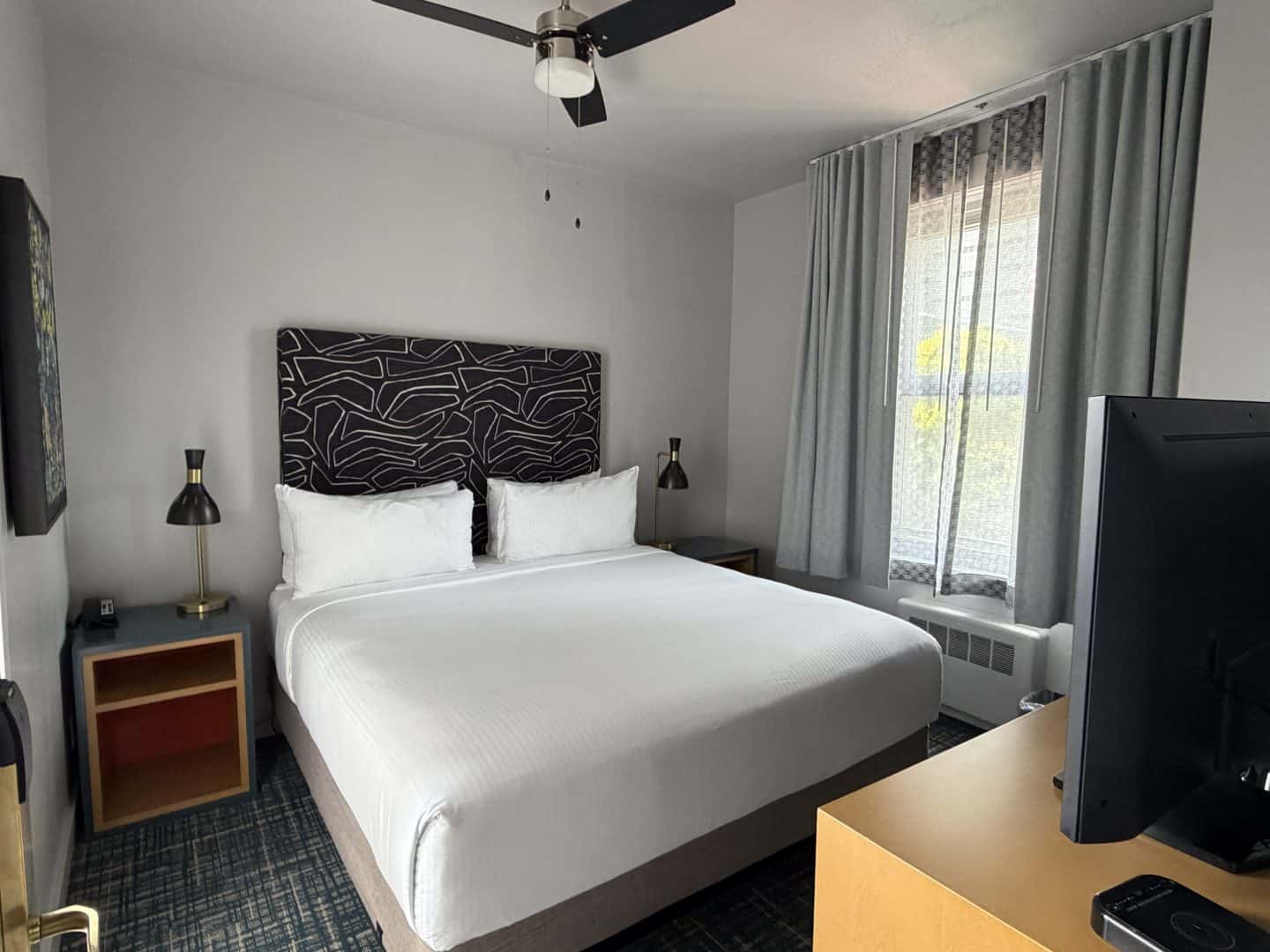 hotel_garrett_sf_room - Adventures with Carli cozy Hotel room with a king bed, nightstands and lamps, with ceiling fan overhead