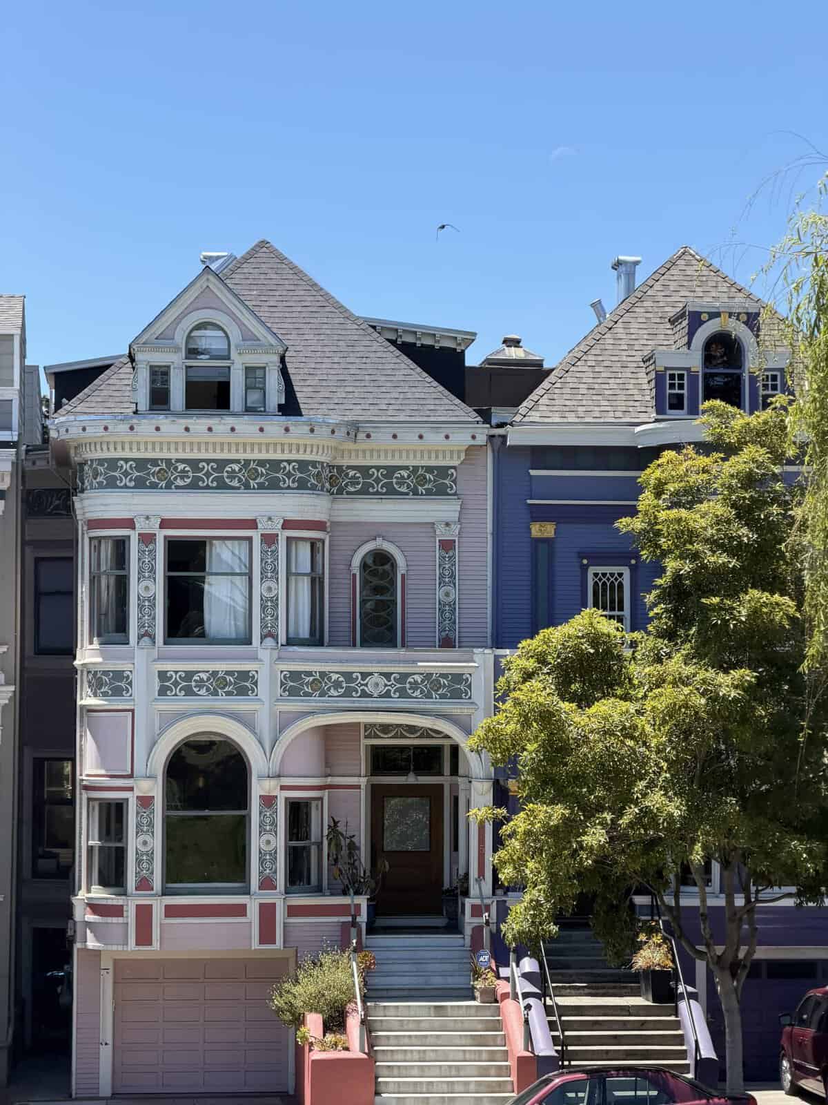 large pink victorian house with green and white trim