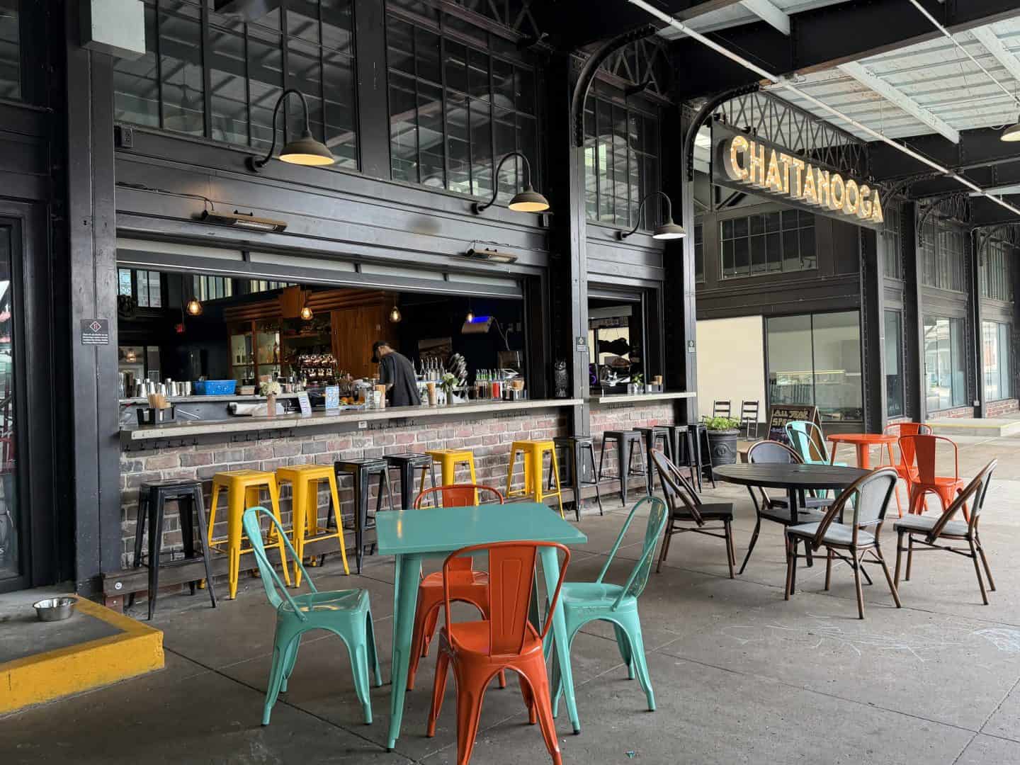 colorful metal seats and tables outside Gate 11 distillery bar in Chattanooga