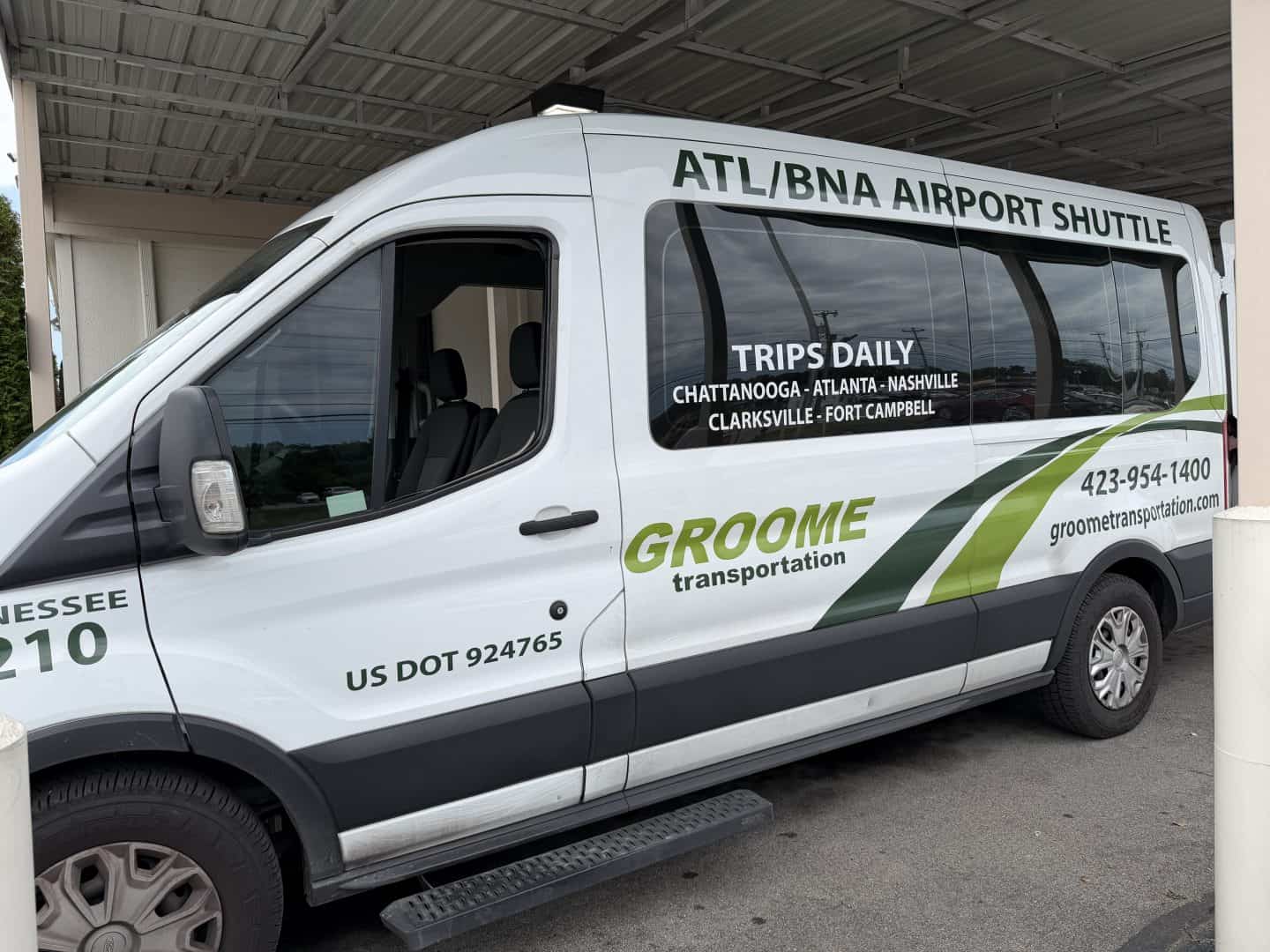 white Groome Transportation van with green graphics and lettering Chattanooga to Nashville shuttle