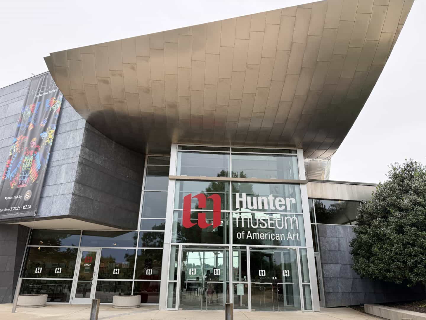 Front entrance of the Hunter Museum of American Art with glass doors and a bold red'm' logo beside white text.