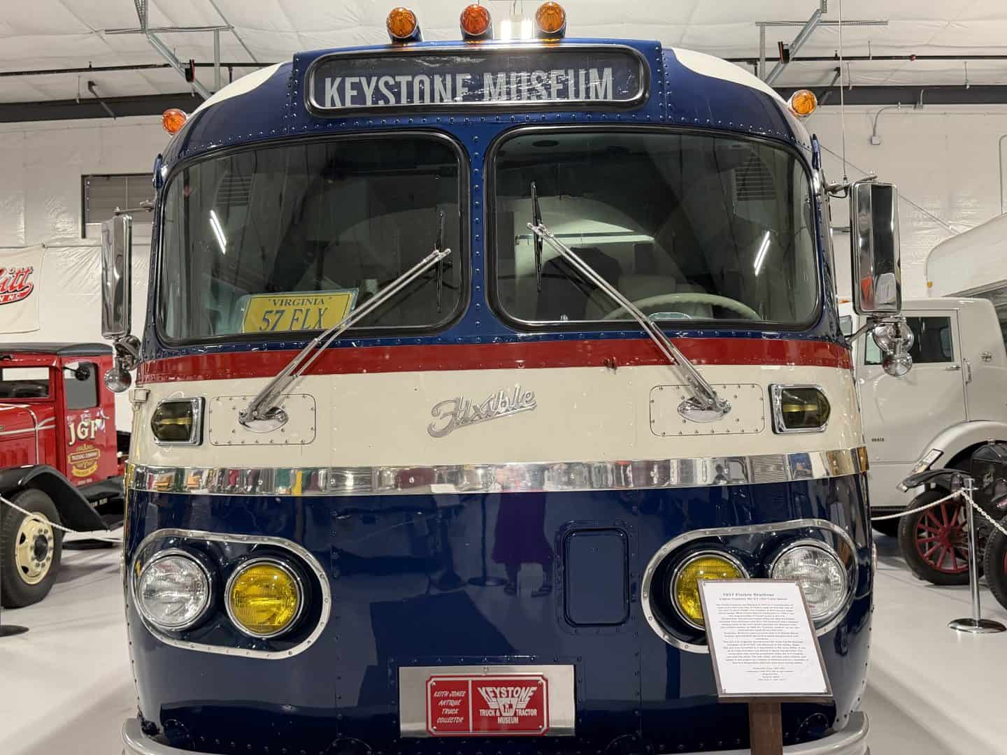 keystone_truck_museum_flixible_bus - Adventures with Carli Front of a vintage blue bus with a Keystone Museum sign on the windshield, chrome trim, and yellow headlights in a museum setting.