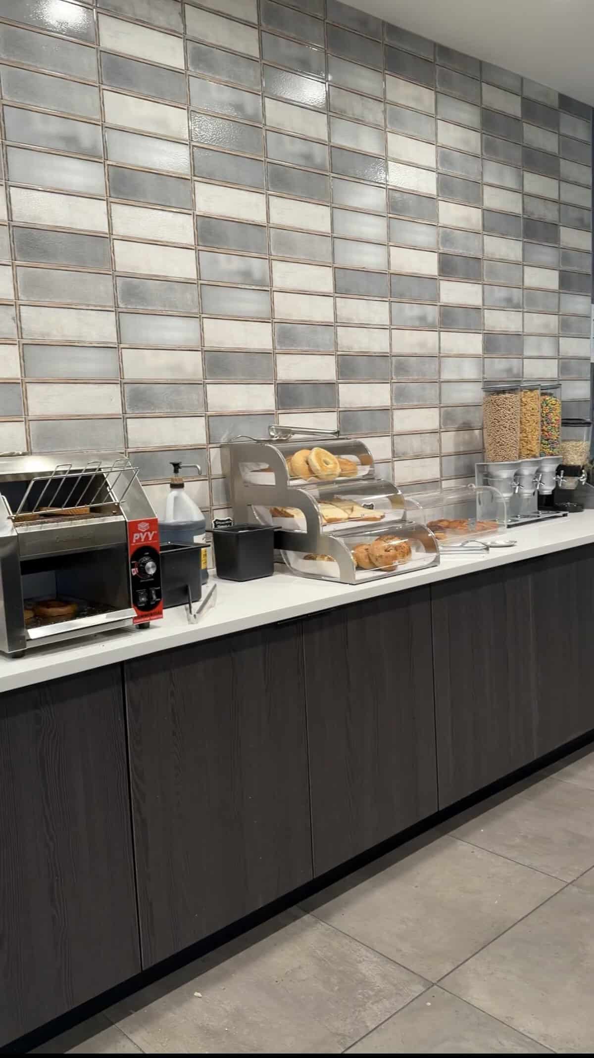 Screenshot - Adventures with Carli Cafe counter with pastry display and cereal dispensers against a tiled wall