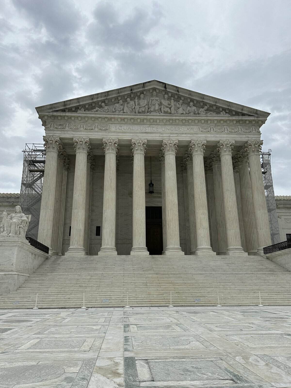 White neoclassical courthouse with tall Corinthian columns and a pediment reading'Equal Justice Under Law' atop steps.