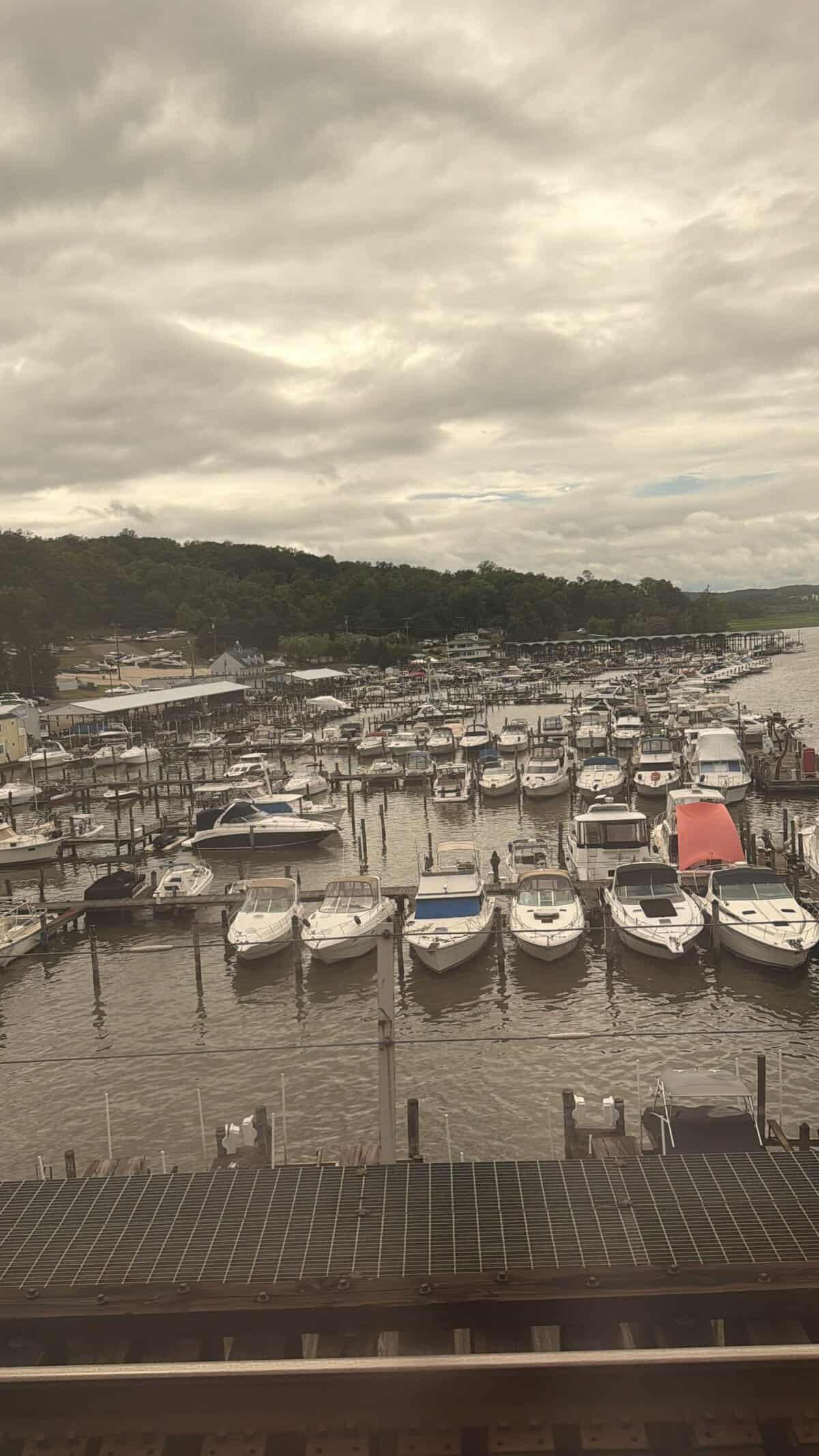 Marina with numerous boats docked along piers under a gray, cloudy sky