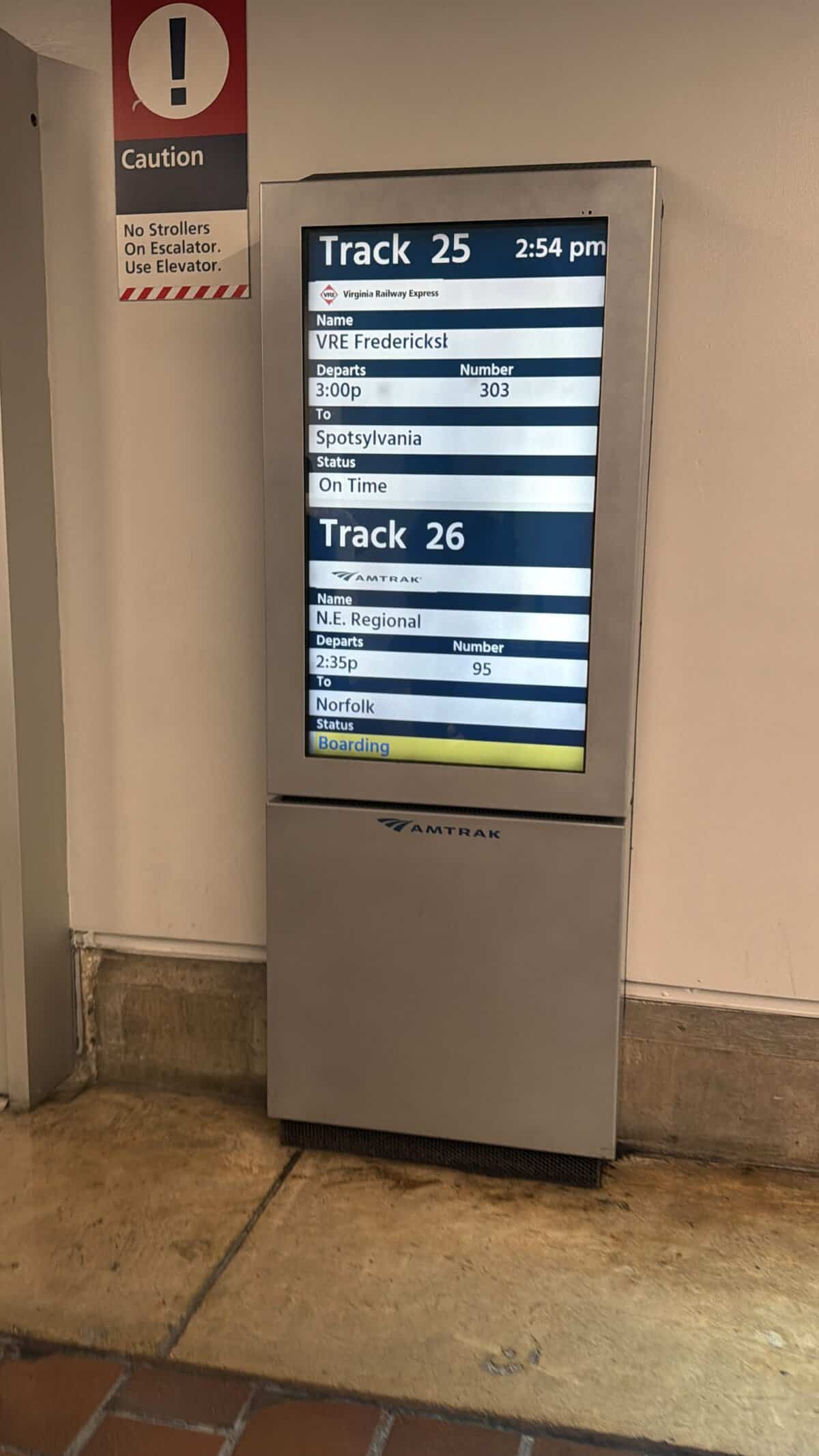 Digital train board showing Track 25 and Track 26 with destinations, times, and status.
